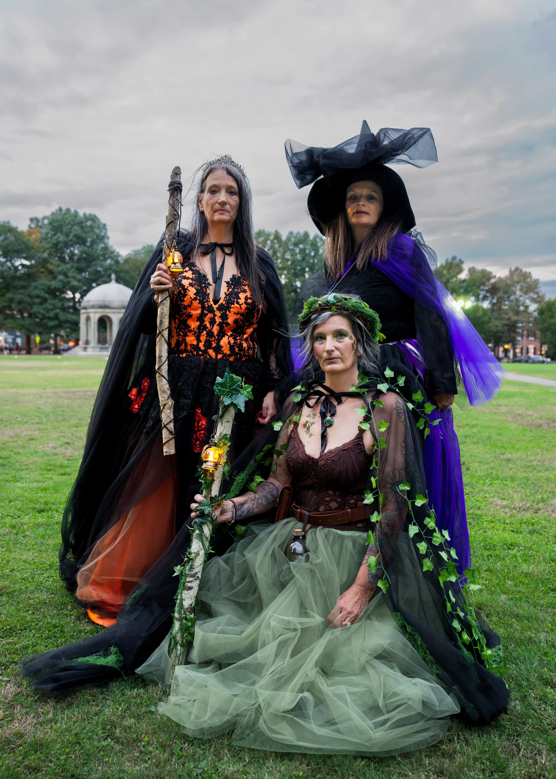 Three costumed women on the lawn at Salem Common