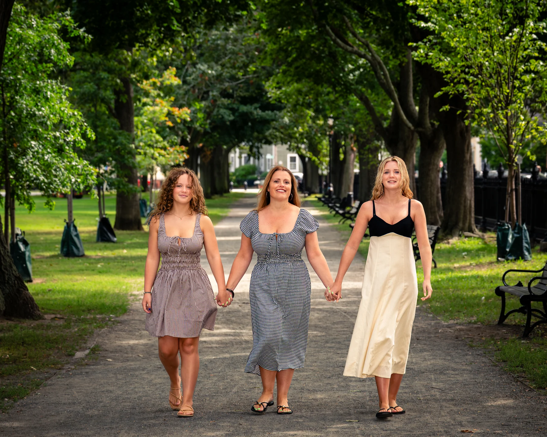 Three women walking beneath the trees at Salem Common